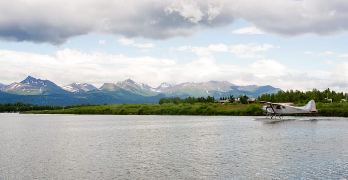 A bush plane performs take off/landing in Alaska with Chugach Mountains in the Background
