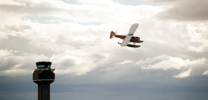 A plane circles around for a water landing on a cloudy day