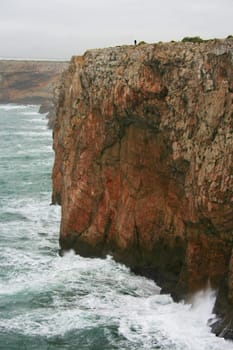 Severe dramatic seascape with fisherman in Cape Saint Vicent cliffs, Porrtugal