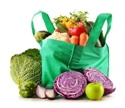 Shopping bag with variety of fresh organic vegetables isolated on white
