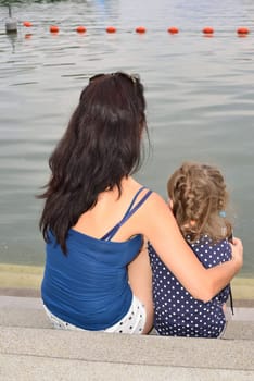 Mother and her little girl contemplating a lake