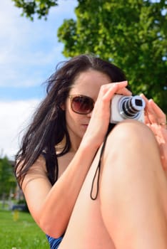 Young woman with a camera taking pictures