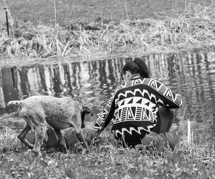 german shorthaired pointer and her owner playing by the water's edig