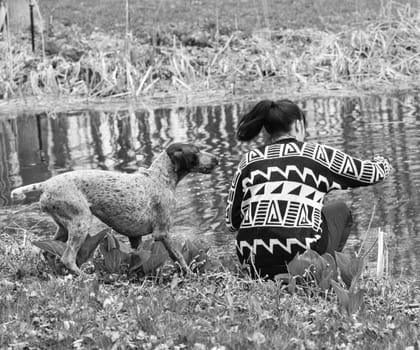 german shorthaired pointer and her owner playing by the water's edig