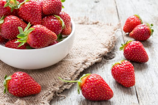 Strawberry in a bowl on wooden background