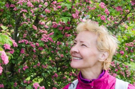 Portrait of a woman in a blossoming hawthorn