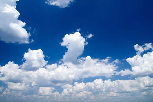 white fluffy clouds with rainbow in the blue sky
