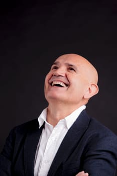 old bald self-confident businessman on a dark background