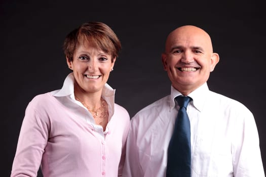 an elderly couple smiling to the camera