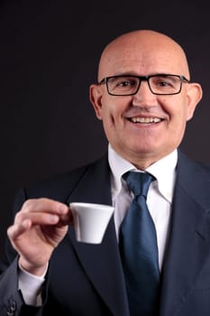 bald old smiling businessman holding a cup of espresso italian coffee