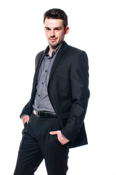 young businessman in a suit is standing casually with hands in pocket. Isolated on white
