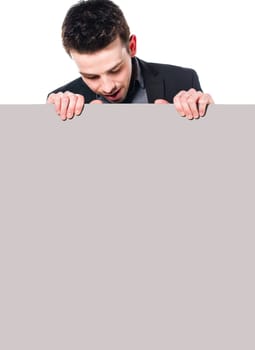 Portrait of young man in business suit looking down at blank sign, Isolated on white.