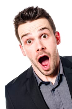 young businessman in a suit looking shocked and surprised with open mouth at the camera. Isolated on white.