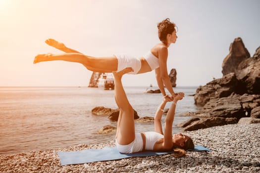 Woman sea yoga. Back view of free calm happy satisfied woman with long hair standing on top rock with yoga position against of sky by the sea. Healthy lifestyle outdoors in nature, fitness concept.