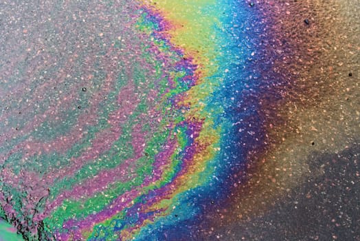 Spills of fuel or oil on the asphalt road as texture or background.