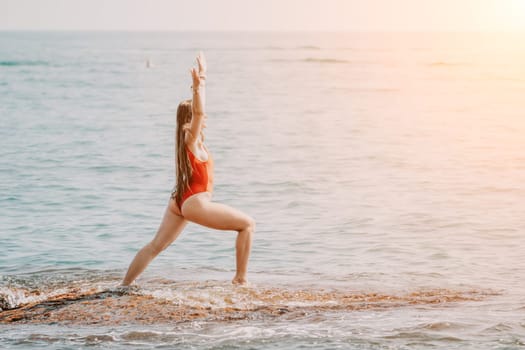 Woman sea yoga. Back view of free calm happy satisfied woman with long hair standing on top rock with yoga position against of sky by the sea. Healthy lifestyle outdoors in nature, fitness concept.