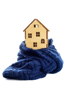 Wooden toy house is wrapped in a warm scarf isolated on white background. House insulation concept. Warm house concept