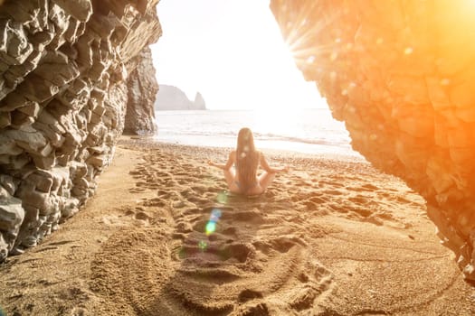 Middle aged well looking woman with black hair doing Pilates with the ring on the yoga mat near the sea on the pebble beach. Female fitness yoga concept. Healthy lifestyle, harmony and meditation.