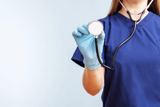 Female doctor in uniform with stethoscope on a blue background. Concept of healthcare and medical or health insurance