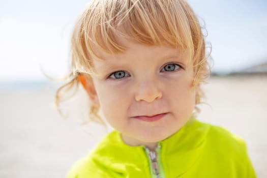 Portrait of a cute blond boy on the beach. The concept of a summer vacation.