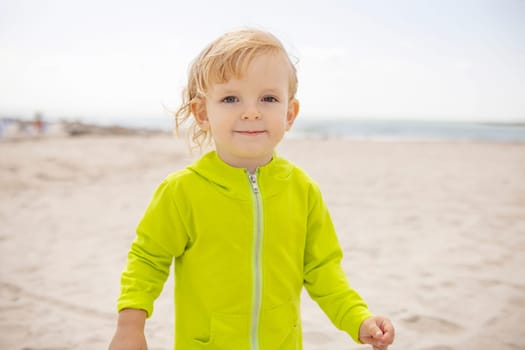 Portrait of a cute blond boy on the beach. The concept of a summer vacation.