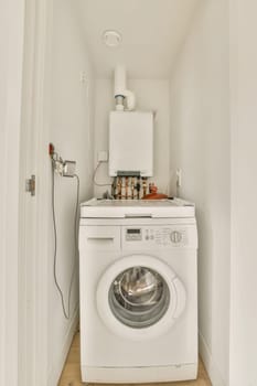 a white washer and dryer in a small laundry room with wood flooring on the left hand side