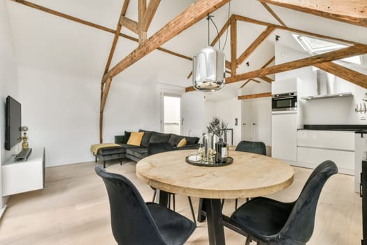 a living room with wood beams on the ceiling and black leather chairs at the table in front of the couch