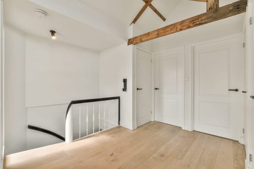 an empty room with wood floors and white walls, including a staircase leading up to the second floor in this house