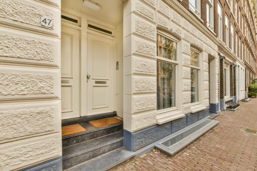 a bricked building with white trim on the front door and two windows in the photo is taken from outside