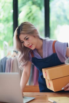 Asian female business owner handles delivery of orders to customers.