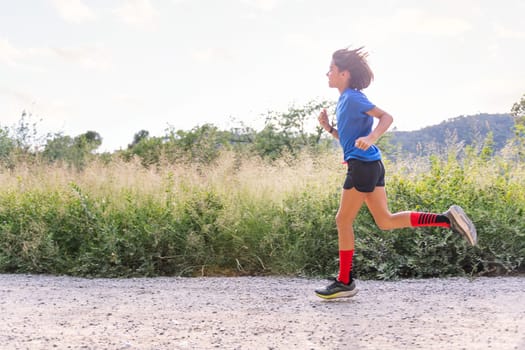 girl running in the countryside, concept of sport for kids in nature and active lifestyle, copy space for text