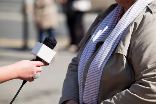 A journalist is making an interview with a microphone