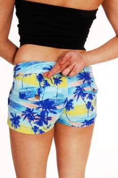 A closeup picture of the back and butt of a young woman in shorts with.her crossed finger, isolated on white background..