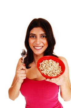 A nice brunette young woman in a red t-shirt holding a bowl of cereal.in her hand for breakfast, isolated on white background..