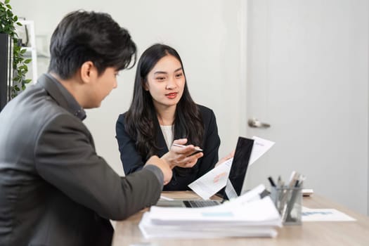 Two business professionals engage in a discussion about financial reports and strategies, emphasizing collaboration and analysis.