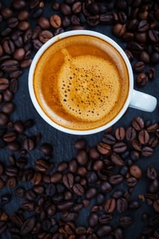 Cup of espresso with coffee beans - top view
