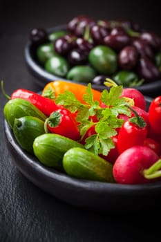 Raw snack vegetable with olives in the background