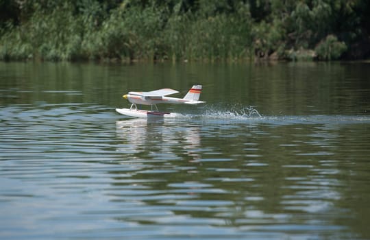 Radio controlled Hydroplane flying and sailing over the Guadiana river surface, Badajoz, Spain