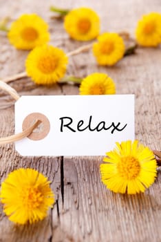 White Tag with the Word Relax on it and many yellow Flowers