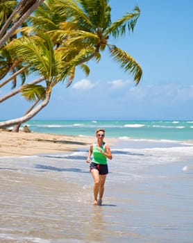 Female runner on a sunny day jogging on the beach