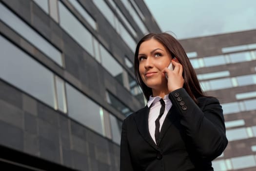 Smiling business woman on the phone at modern building