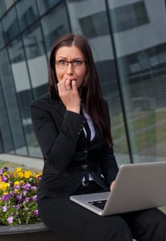 Frightened and stressed beautiful business woman biting her fingers