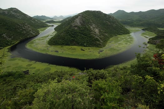 The landscape at Rijeka Crnojevica with the river Rijeka Crnojevica at the western end of the Skadarsko Jezero lake or Skadar lake in Central Montenegro in Montenegro in the Balkans on the Mediterranean Sea in Europe.