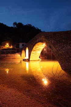 The landscape with the stone bridge on the shores of Lake Skadar or Skadarsko Jezero ini Rijeka Crnojevica in Montenegro in Europe.