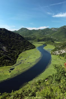 The landscape at Rijeka Crnojevica with the river Rijeka Crnojevica at the western end of the Skadarsko Jezero lake or Skadar lake in Central Montenegro in Montenegro in the Balkans on the Mediterranean Sea in Europe.