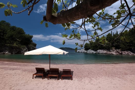 A beach at Sveti Stefan on the Mediterranean coast in Montenegro in the Balkans in Eastern Europe.