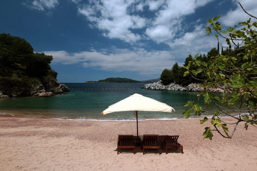 A beach at Sveti Stefan on the Mediterranean coast in Montenegro in the Balkans in Eastern Europe.
