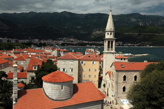 The old town with the church Of Sv. Ivan Krstitelji of the Adriatic city of Budva with many new apartments in Montenegro in the Balkans on the Mediterranean Sea in Europe.