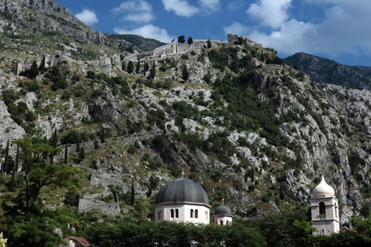 The mountain landscape with the city wall of Kotor in the inner bay of Kotor on the Mediterranean Sea in Montenegro in Europe.