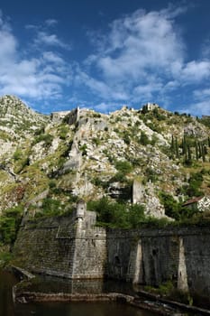The mountain landscape with the city wall of Kotor in the inner bay of Kotor on the Mediterranean Sea in Montenegro in Europe.